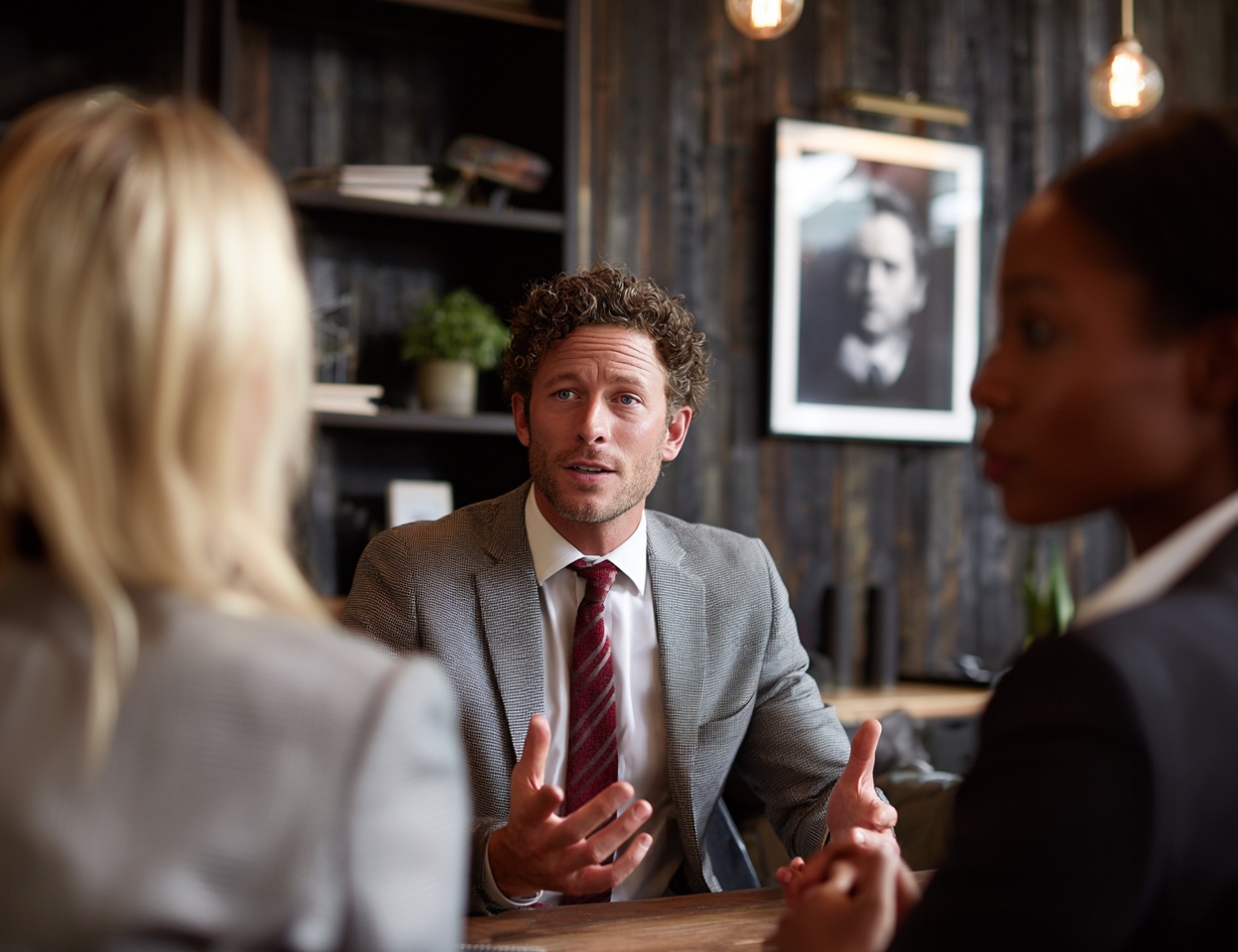 Professionals in conversation in an office setting.